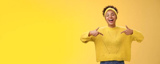 Уверенная красивая уходящая черная милая девушка 20 лет в свитере с афро-прической, указывая на то, что он поднимает голову высокомерным смехом, хвастаясь своими личными достижениями, предлагает себя. - Фото, изображение