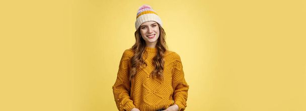スタイリッシュでフレンドリーな女性従業員の頭を傾け笑顔快適なホールドポケットジーンズ自己保証、自信を表明到達成功、黄色の背景を決定. - 写真・画像