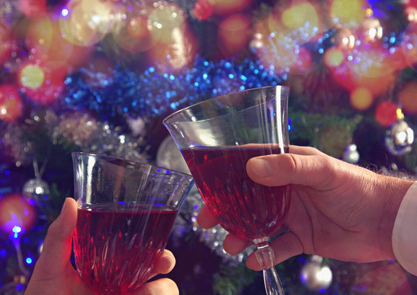 Люди касаются стаканов на рождественской вечеринке с Боке позади - Фото, изображение