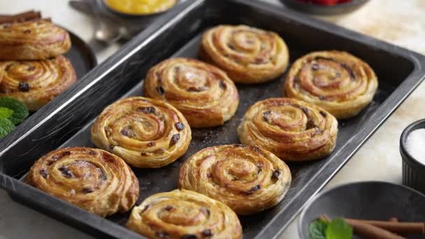 Swedish homemade puff pastry cinnamon rolls with raisins placed on oven iron tray. Flat lay, top view. - Footage, Video