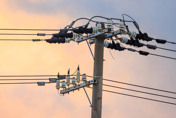 Líneas de transmisión de alto voltaje sobre poste eléctrico al amanecer. Foto de alta calidad - Foto, imagen