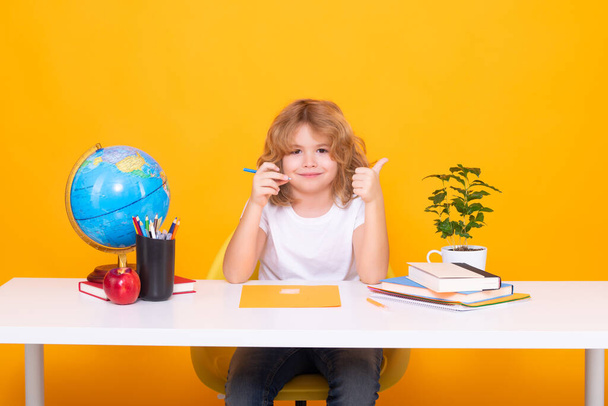 Child writing lesson. Little student school child isolated on studio background. Portrait of nerd student with school supplies - Photo, Image