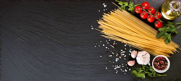 Tészta, spagetti és főzőcskézés fekete pala felületen. Olasz konyha koncepció, éttermi menü, recept sablon. Felülnézet, lapos fektetés, mockup, banner, fejléc szöveges másolási hellyel - Fotó, kép