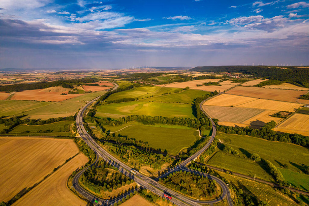 Aerial madártávlatból tipikus Ardennek zöld mező rétek és dombos táj is mutatja autópálya és épületek te messze háttérben a német környezetben. Németország. - Fotó, kép