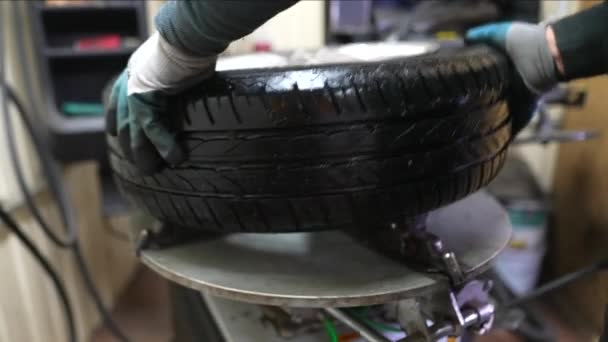 Engineer balancing car wheel on balancer in workshop - Footage, Video
