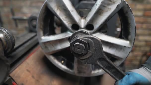 Engineer balancing car wheel on balancer in workshop - Footage, Video