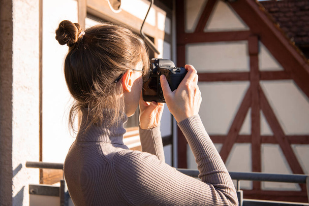 Jeune femme prenant des photos sur l'appareil photo dans la rue. - Photo, image