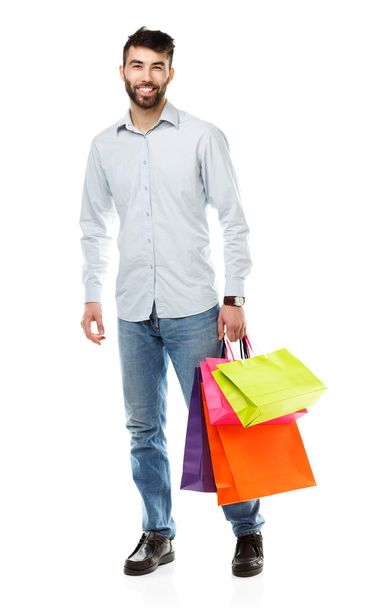 Handsome man holding shopping bags on white background - 写真・画像
