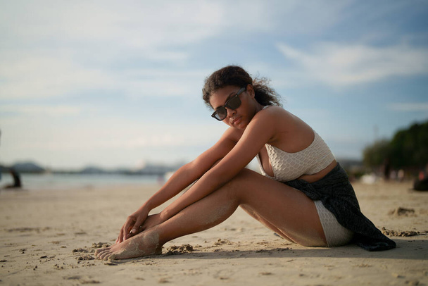 Mujer africana sentada en la playa. Retrato sexy dama africana viajar ping y relajarse en el verano con la naturaleza tropical. - Foto, imagen