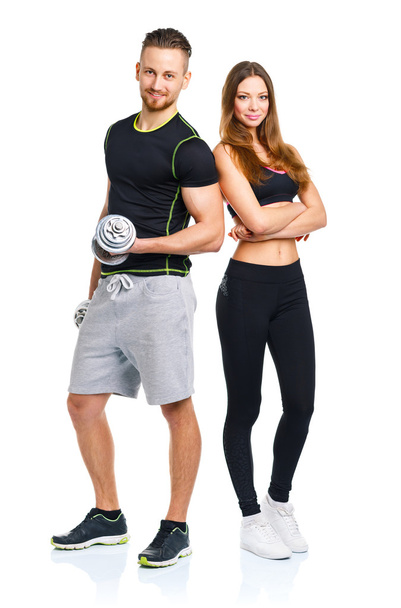 αθλητική άνδρας και γυναίκα με αλτήρες στο λευκό - Φωτογραφία, εικόνα