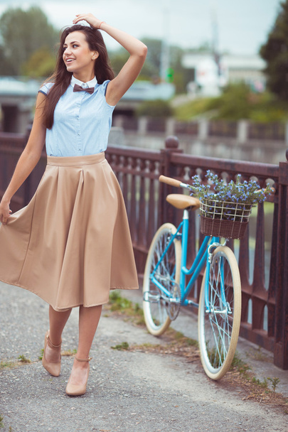Jovem mulher bonita, elegantemente vestida com bicicleta no par
 - Foto, Imagem