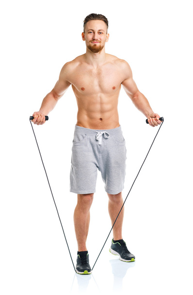 Athletic attractive man jumping on a rope on the white - Foto, Imagen