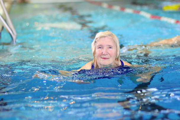 Active senior woman swimming in the pool - Фото, изображение