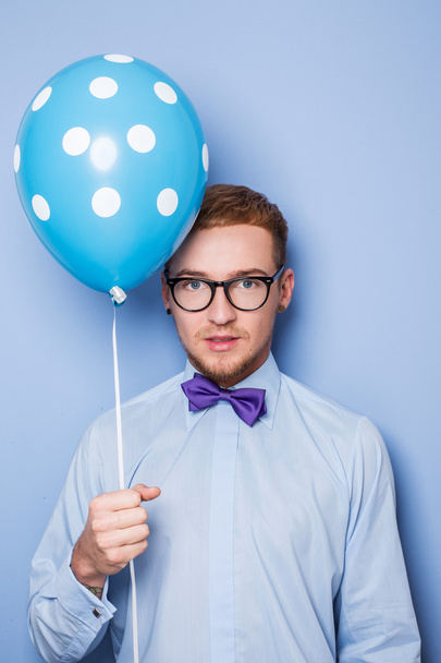 Un joven atractivo con un globo azul en la mano. Fiesta, cumpleaños, San Valentín
 - Foto, Imagen