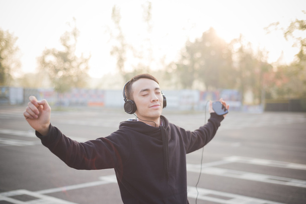Joven asiático hombre en auriculares bailando
 - Foto, imagen