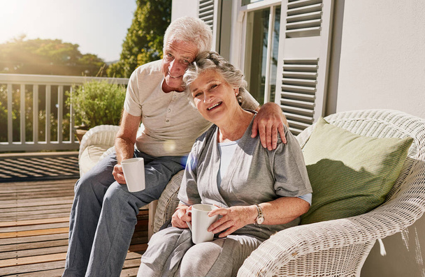 Haciendo que nuestra jubilación sea cómoda. una feliz pareja de ancianos disfrutando de su café de la mañana en el patio en casa - Foto, imagen