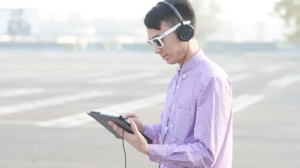 Aziatische man luisteren muziek met Tablet PC - Video