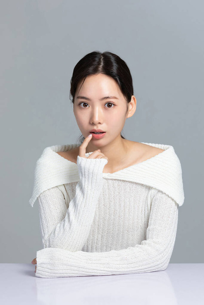 beautiful young Korean Asian woman portrait studio photo in winter skin beauty and cosmetics concept, hand motion - Zdjęcie, obraz