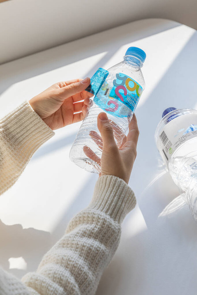 eco friendly habits hand gesture, remove the bottle label - Фото, изображение