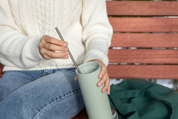 eco friendly habits hand gesture, sticking a stainless steel straw in a tumbler - 写真・画像