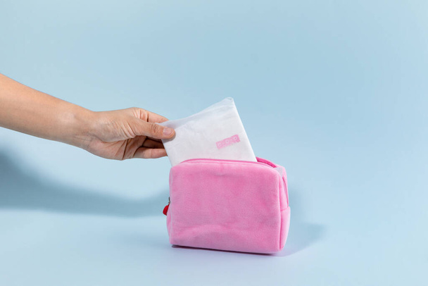 woman menstrual products, taking out the sanitary pad from pouch - Fotoğraf, Görsel