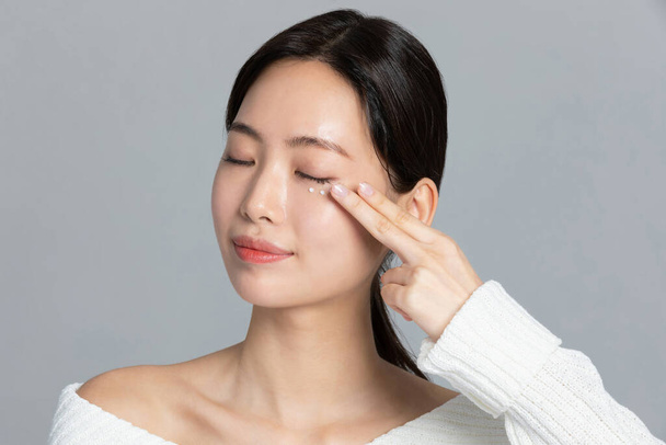 beautiful young Korean Asian woman portrait studio photo in winter skin beauty and cosmetics concept__use eye cream - Φωτογραφία, εικόνα