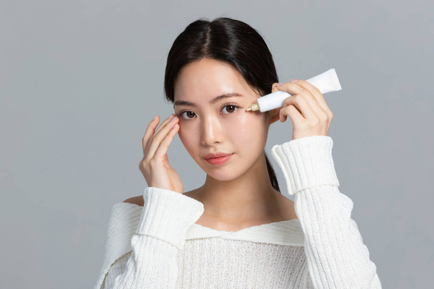 beautiful young Korean Asian woman portrait studio photo in winter skin beauty and cosmetics concept__use eye cream - Valokuva, kuva