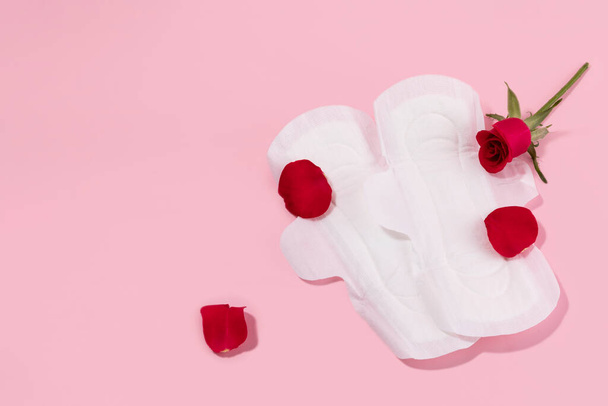 woman menstrual products, sanitary pads and rose - Fotó, kép