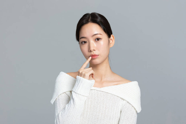 красива корейська жінка-портретистка фотографія в зимовій шкірі краса і косметика концепції, турбуючись про губи - Фото, зображення