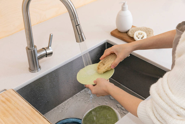 eco friendly habits hand gesture, washing dishes with an eco friendly sponge - Foto, afbeelding