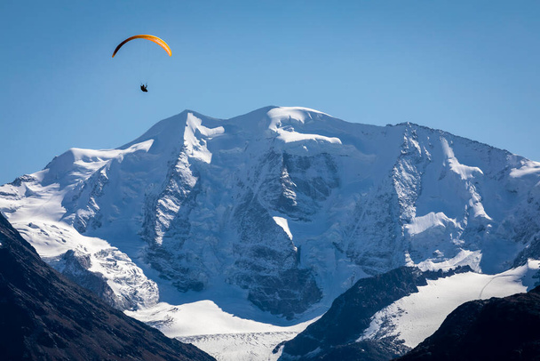 Paralotniarstwo nad pasmem górskim Bernina i Palu z lodowcami w Alpach Szwajcarskich, Engadine, Szwajcaria - Zdjęcie, obraz
