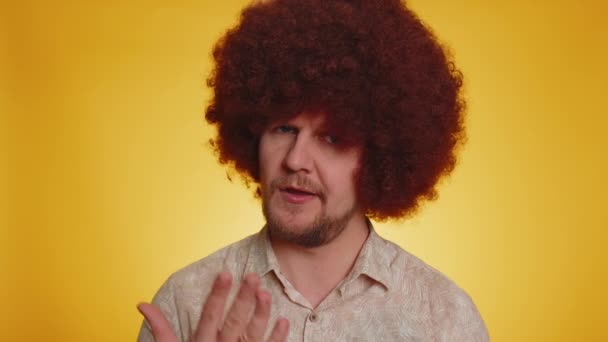 Upset tired bored man with lush afro hairstyle making face palm gesture, feeling bored, disappointed in result of work, bad news. Young guy disappointed, helpless isolated on yellow studio background - Footage, Video