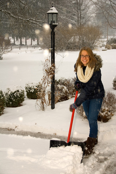 A shoveling hó tetején a műút lány - Fotó, kép
