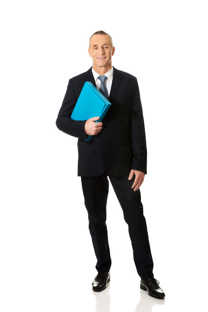 Mature businessman holding a binder - 写真・画像