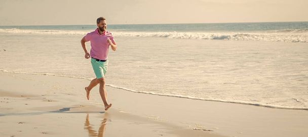 Άντρας τρέχει και πηδάει, λάβαρο με χώρο αντιγραφής. αθλητή τρέχει γρήγορα για να κερδίσει στη θάλασσα την ημέρα. πρωινή γυμναστική. υγιής άνθρωπος τρέχει - Φωτογραφία, εικόνα