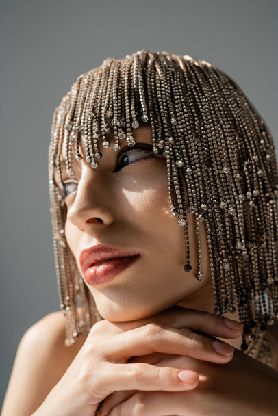 close up of young woman with metallic jewelry headwear posing while looking away isolated on grey  - Foto, Imagen