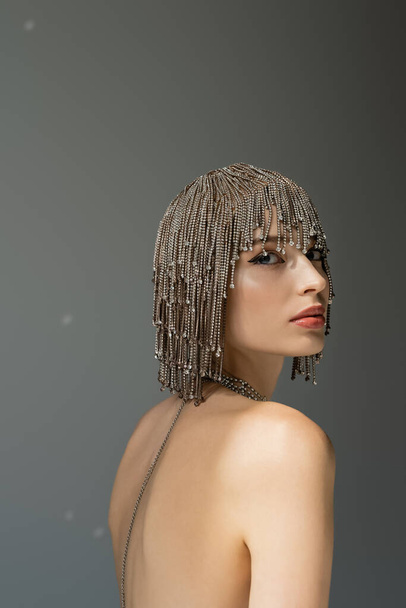 portrait of young woman with metallic jewelry headwear looking at camera on grey  - Photo, image