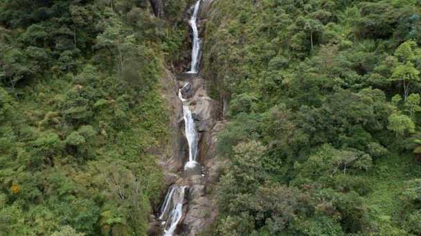 Прекрасные водопады окружены пышной и зеленой растительностью в эквадорских Андах, видимых с воздуха с беспилотником - Фото, изображение