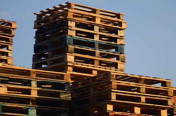 Wooden boxes and pallets. Many pallets stacked in stock, warehouse pallets, sky background - Foto, imagen