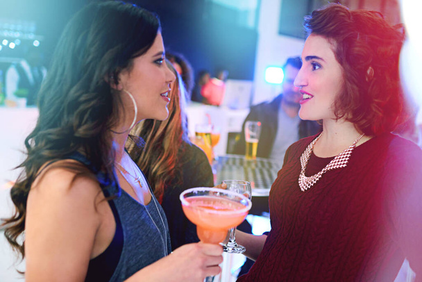Nadrabiam zaległości przy drinkach. dwie młode kobiety pijące koktajle na imprezie towarzyskiej - Zdjęcie, obraz