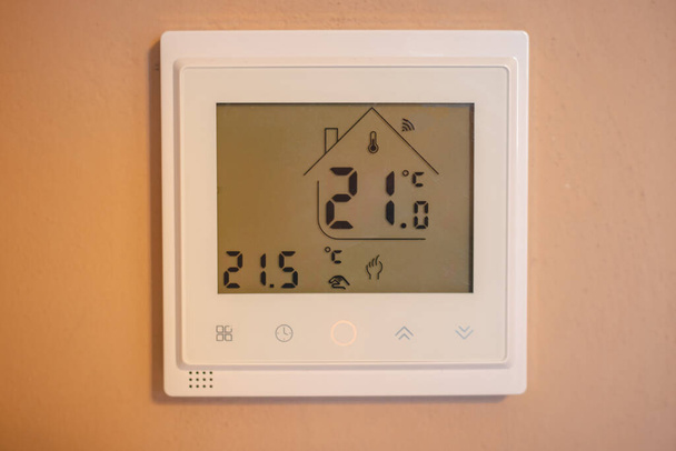 温度を維持し、エネルギー危機のために部屋の温度の程度を減らすことを見て、家族の時間で加熱するためのオンライン温度調節器。省エネルギー. - 写真・画像