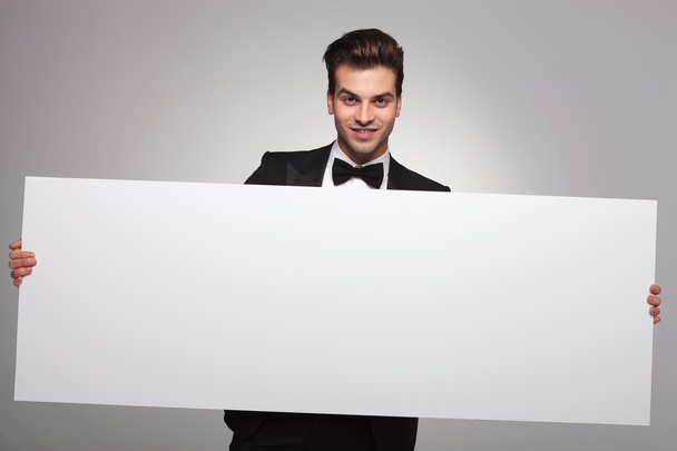 Homem de negócios elegante segurando um quadro em branco
 - Foto, Imagem