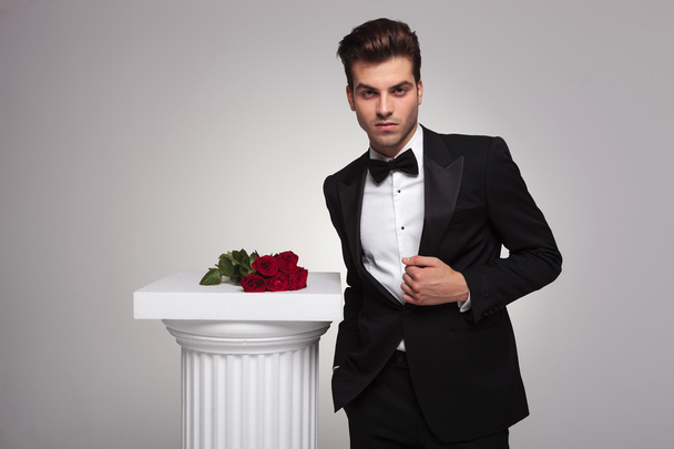 Elegante jonge zakenman vaststelling zijn tuxedo  - Foto, afbeelding