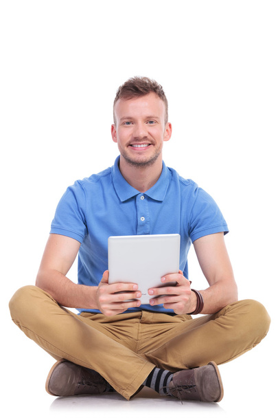 seated young man holds his tablet - Photo, Image