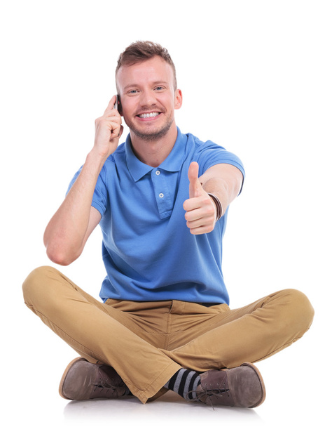 Young casual man on the phone shows thumb up - Photo, Image