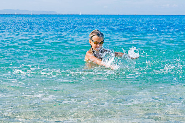 girl in glasses splashes into the sea - Photo, Image