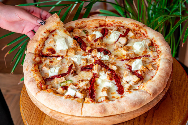Maukas ja iso pizza erilaisilla lihatyypeillä. Top näkymä kuumaa pizzaa. Iso ja maukas pizza aurinkokuivatuilla tomaateilla ja fetajuustolla - Valokuva, kuva