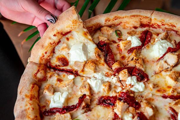 Maukas ja iso pizza erilaisilla lihatyypeillä. Top näkymä kuumaa pizzaa. Iso ja maukas pizza aurinkokuivatuilla tomaateilla ja fetajuustolla - Valokuva, kuva