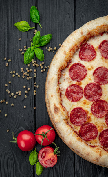 Pizza pepperoni savoureuse et ingrédients de cuisine tomates basilic Vue de dessus de pizza pepperoni piquante. - Photo, image