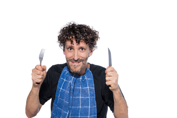 Uomo di mezza età con coltello, forchetta e tovagliolo sul collo, pronto da mangiare, su sfondo bianco. - Foto, immagini